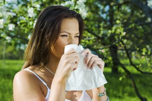 Eine Frau mit Sommergrippe und Schnupfen im Freien